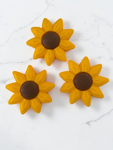 Inquadratura dall'alto di tre fidget toy Girasole Clicker di colore giallo e marrone stampati in 3D