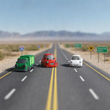 Inquadratura frontale in primo piano dei tre modellini Namii Wheels — il camioncino verde, la spider bianca e la macchinina rossa con corpi snodati e ruote fisse — ambientati all'aperto con uno sfondo che ritrae le classiche strade americane.