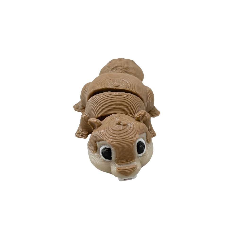 Inquadratura ravvicinata e leggermente dall'alto in primo piano di un modellino articolato Namii Mini Marmotta in plastica marrone chiaro, con corpo snodato, dettagli del musetto definiti ed occhi neri.